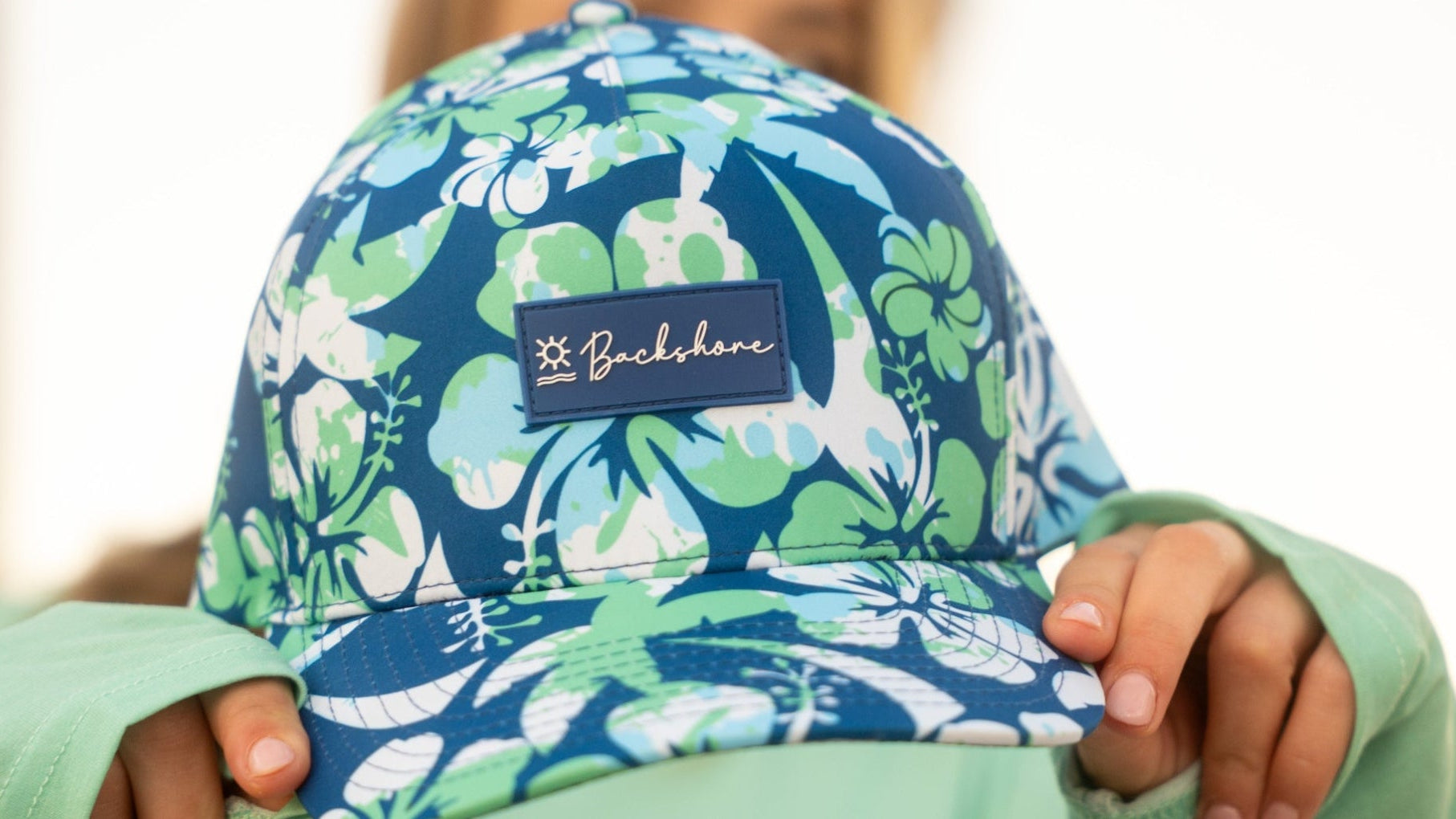  blue and green floral hat with a visible brand logo.
